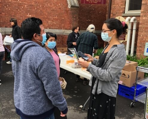 Family signing up at UIDN’s weekly market.