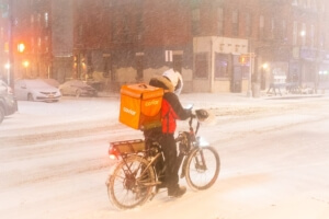 Food delivery via bicycle in a snow storm.