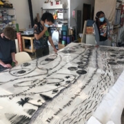 Photo of teens painting on fabric.