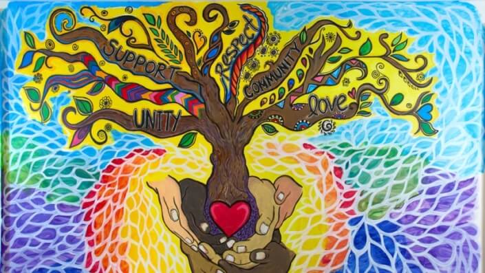 Brightly colored mural of a tree with branches as support, community, love, and unity. The tree roots are held by hands.