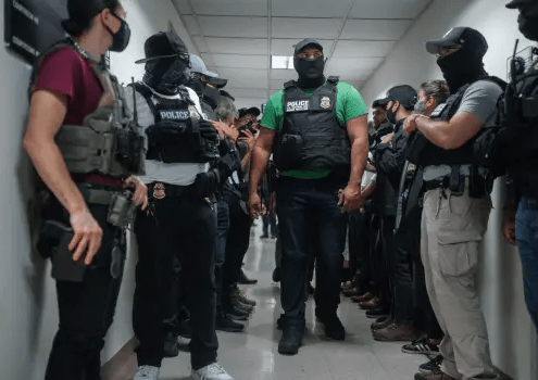 Masked federal agents wait outside an immigration courtroom, July 8, 2025, in New York. (AP Photo/Olga Fedorova)