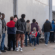 Asylum seekers queue at the entrance of Mexico's Refugee Help Commission and UNHCR offices in Tijuana, Mexico on January 24, 2025. Guillermo Arias/AFP via Getty Images