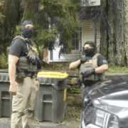 Two masked officers shown in Eddyville, NY, in July 2026.